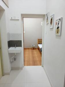 a white bathroom with a sink and a bed at Meadows Homestay in Madurai