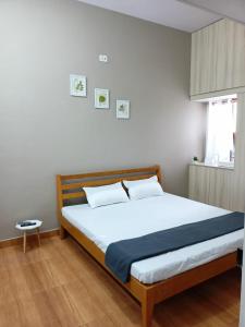 Meadows Homestay في مادوراي: غرفة نوم بسرير كبير مع شراشف بيضاء