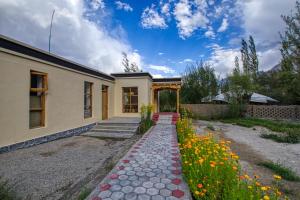 a house with a pathway in front of it with flowers at Chalet Seabuckthorn - Hunder in Hundar