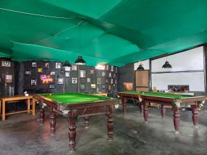 two pool tables in a room with green at The Freedom Huts in Pokhara