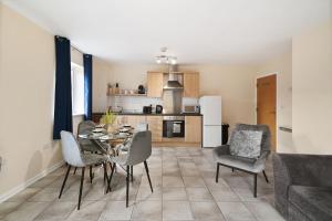 a kitchen and dining room with a table and chairs at Spacious Modern Flat with Free Parking by Xenox Property Group in Stoke on Trent