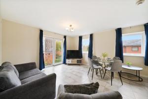 a living room with a couch and a table at Spacious Modern Flat with Free Parking by Xenox Property Group in Stoke on Trent