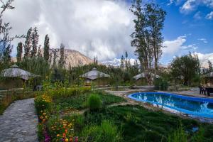 a garden with a swimming pool and a mountain at Chalet Seabuckthorn - Hunder in Hundar
