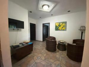 a living room with two chairs and a tv at Blissful hill top Apartment in Praslin