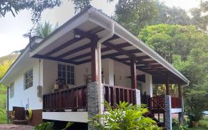 a house with a porch with a deck at Blissful hill top Apartment in Anse Possession