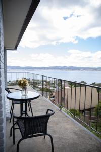 a balcony with a table and chairs and a view of the water at Cheerful 3 bedrooms home with Sea View in Sandy Bay