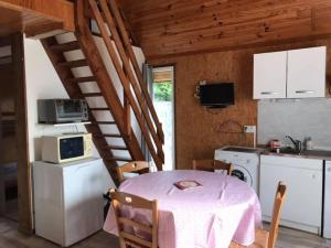 cocina con mesa y cocina con electrodomésticos blancos en Chalet avec vue imprenable, en Rocamadour