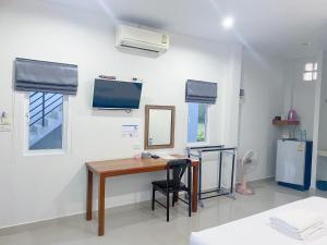 een kamer met een bureau en een tv aan de muur bij SP view Resort in Pran Buri