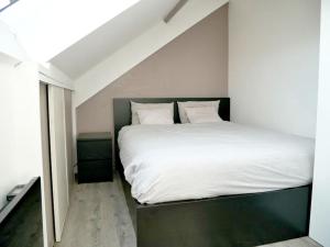 a bedroom with a large bed with white sheets and pillows at Bobigny : 2 pièces proche a86 et commerces in Bobigny