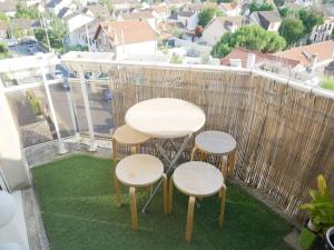 a table and two stools on a balcony at Bobigny : 2 pièces proche a86 et commerces in Bobigny