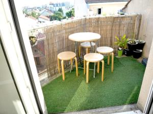 a group of tables and stools on a balcony at Bobigny : 2 pièces proche a86 et commerces in Bobigny