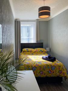 um quarto com uma cama com um cobertor amarelo em Helens Lybster cosy cottage on NC500 em Lybster