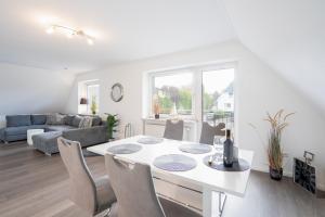 a white living room with a white table and chairs at MiBa Mare Ferienwohnung "Sol" in Scharbeutz