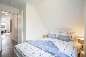 a bedroom with a bed with blue and white sheets at MiBa Mare Ferienwohnung "Stella" in Scharbeutz