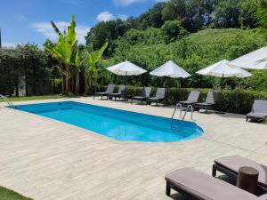 a swimming pool with lounge chairs and umbrellas at Hotel Rural Sagarlore in Astigarraga