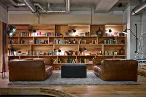 a living room with two leather chairs and bookshelves at Generator Berlin Mitte in Berlin