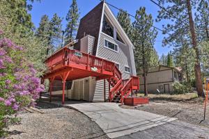 Una casa grande con una terraza roja en el lateral. en Big Bear Retreat with Fenced Yard Near Ski Resorts! en Big Bear Lake