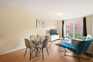 een woonkamer met een eettafel en stoelen bij Fully Furnished 2 BR Flat with Free Parking in Stoke on Trent