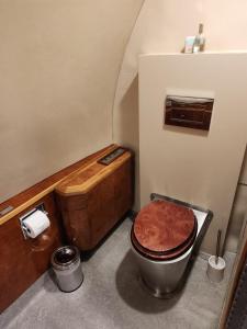 a bathroom with a wooden toilet and a tub at AEROTEL VIP in Hoedspruit