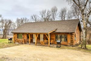 una cabaña de madera con mesas y sillas frente a ella en Cabin Near River - Treehouse Masters Stayed Here! en Ferryville