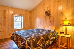 1 dormitorio con 1 cama en una pared de madera en Cabin Near River - Treehouse Masters Stayed Here! en Ferryville
