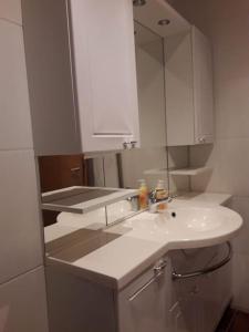 a white bathroom with a sink and a mirror at Ferienwohnung Aelit in Kitzingen