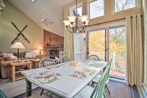 a dining room with a table and chairs and a living room at Ski-in Ski-Out Okemo Oasis with Deck and Mtn View! in Ludlow