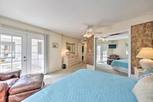 um quarto com uma cama azul e um sofá em Quiet Sun City Home with Grill - Golf and Hike Nearby! em Sun City