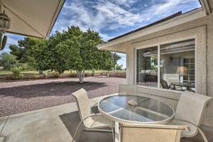 a patio with a table and chairs and a window at Quiet Sun City Home with Grill - Golf and Hike Nearby! in Sun City