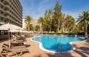 a large swimming pool with lounge chairs and umbrellas at Sol Palmanova All Inclusive in Palmanova