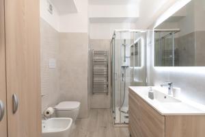 a white bathroom with a sink and a toilet at Appartamento Moderno in Centro città in SantʼAgata di Militello