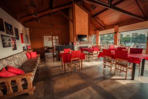 Pousada Marco Polo في كامبوس دو جورداو: غرفة طعام مع طاولات وكراسي حمراء