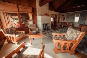 uma sala de estar com cadeiras de baloiço e uma lareira em Pousada Marco Polo em Campos do Jordão