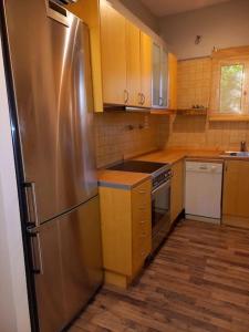 a kitchen with a stainless steel refrigerator and wooden cabinets at Modern and Cosy Apartment in Athens