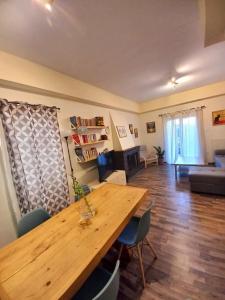 uma sala de estar com uma mesa de madeira e um sofá em Modern and Cosy Apartment em Atenas