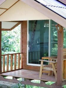 a screened in porch with a bench on it at Phusam Big Resort in Koh Mook