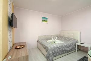 a small bedroom with a bed and a table at Stone Gate Apartment #1 in Bucharest