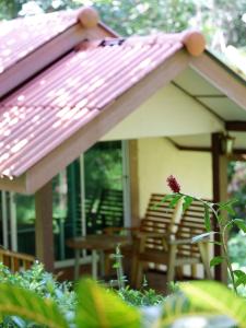 a porch with chairs and a pink roof at Phusam Big Resort in Ko Mook