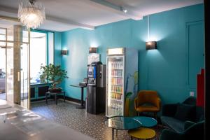 Cette chambre est dotée d'un mur bleu et d'un réfrigérateur. dans l'établissement Hotel de Normandie, à Lyon