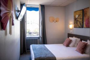 a hotel room with a bed and a window at Hotel de Normandie in Lyon