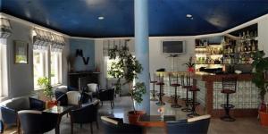 un bar con sillas y mesas y un techo azul en Mountain View Hotel en Kyrenia
