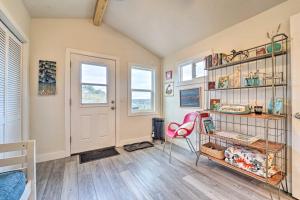 a room with a book shelf and a pink chair at Studio with Mountain Views, Less Than 30 Min to Durango! in Mancos