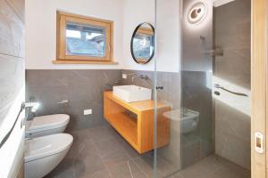 a bathroom with a toilet and a sink and a mirror at Violet a due passi da Bormio in Valdidentro