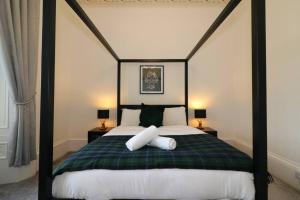 um quarto com uma cama de dossel e 2 almofadas em 10 Bedrooms Pool Table Garden Piano em Glasgow
