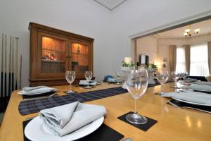 uma mesa de jantar com copos de vinho e guardanapos em 10 Bedrooms Pool Table Garden Piano em Glasgow