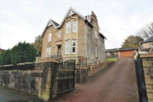 an old stone house with a fence in front of it at 10 Bedrooms Pool Table Garden Piano in Glasgow