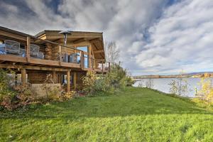 a house on the shore of a body of water at Fairbanks Log Cabin with Waterfront Deck and Views! in Fairbanks