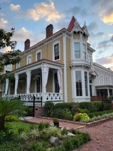 una gran casa amarilla con una torreta blanca en Thomas Weihs Haus en Savannah