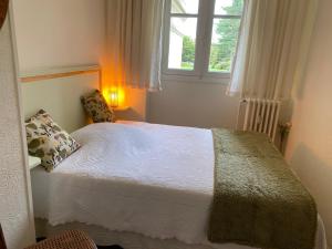 a small bedroom with a bed with a window at Le parc de l'Hermitage in Le Touquet-Paris-Plage