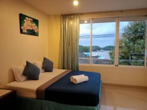 a bedroom with a bed and a window with a view at Marina Seaview Krabi in Krabi town